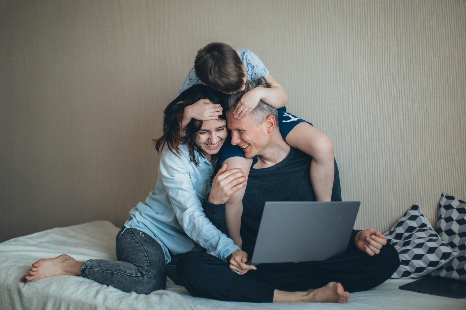 Family enjoying time together while working on a laptop at home.